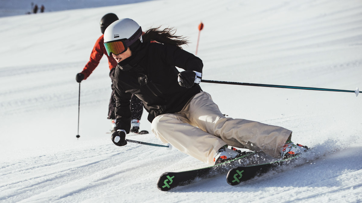 Woman Riding Skis Down Slope